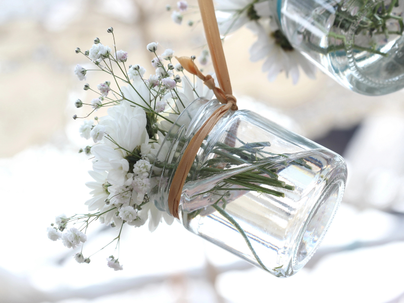Uporabite lahko steklene kozarce, ki so vam ostali od vložene hrane, jih privežite na trakove v naravnih odtenkih in vanje vstavite pomladno cvetje. Uporabite lahko steklene kozarce, ki so vam ostali od vložene hrane, jih privežite na trakove v naravnih odtenkih in vanje vstavite pomladno cvetje.